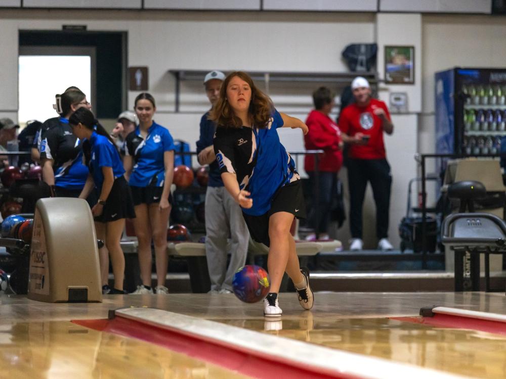 A member of Penn State Behrend's women's bowling team rolls the ball.