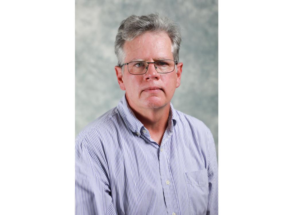 directory photo of gray-haired person with wire-rimmed glasses