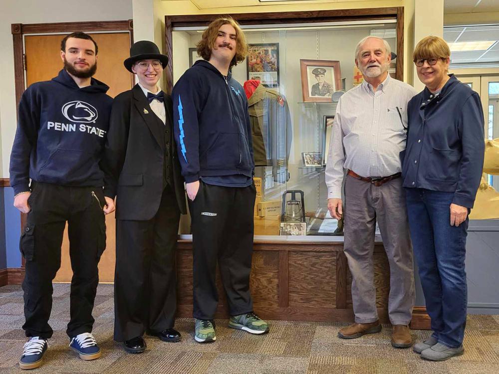 Left to right: Cinnsire Warner, Emma Moniz, Will Auman, Michael Halloran, and Debbie Canole stand at the new exhibit honoring John C. Halloran.