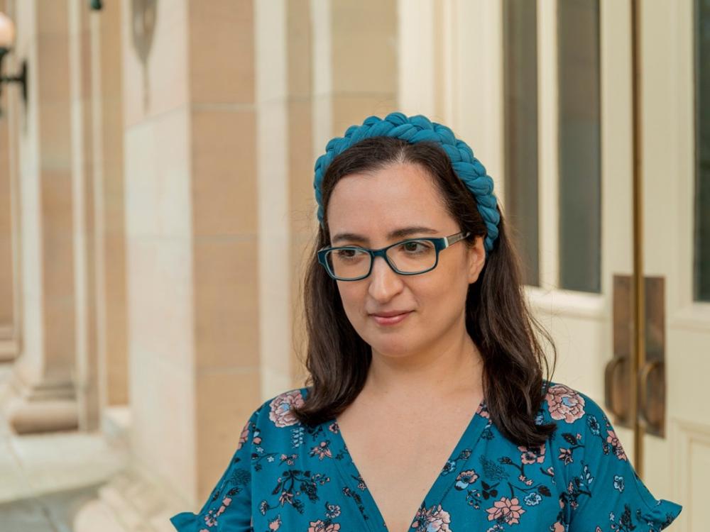 Kate Manne wearning a bright blue blouse and headband