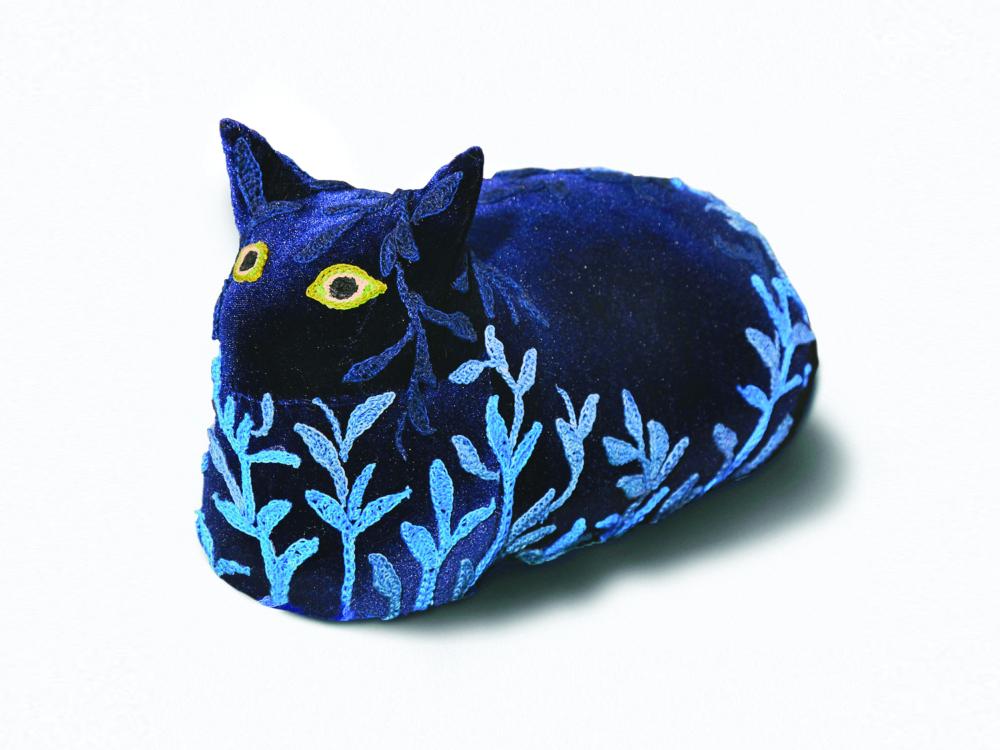 A three dimensional artwork shaped like a blue cat with yellow eyes and covered in vines