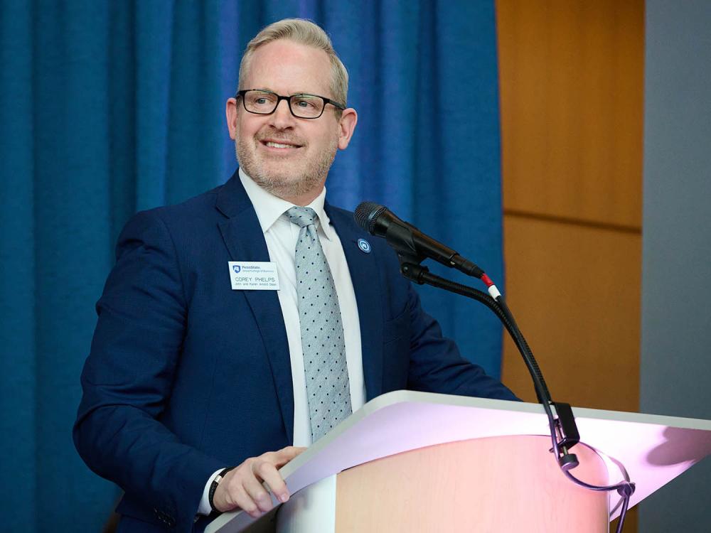 A photo of Smeal dean Corey Phelps speaking at a lectern in the Business Building Atrium.