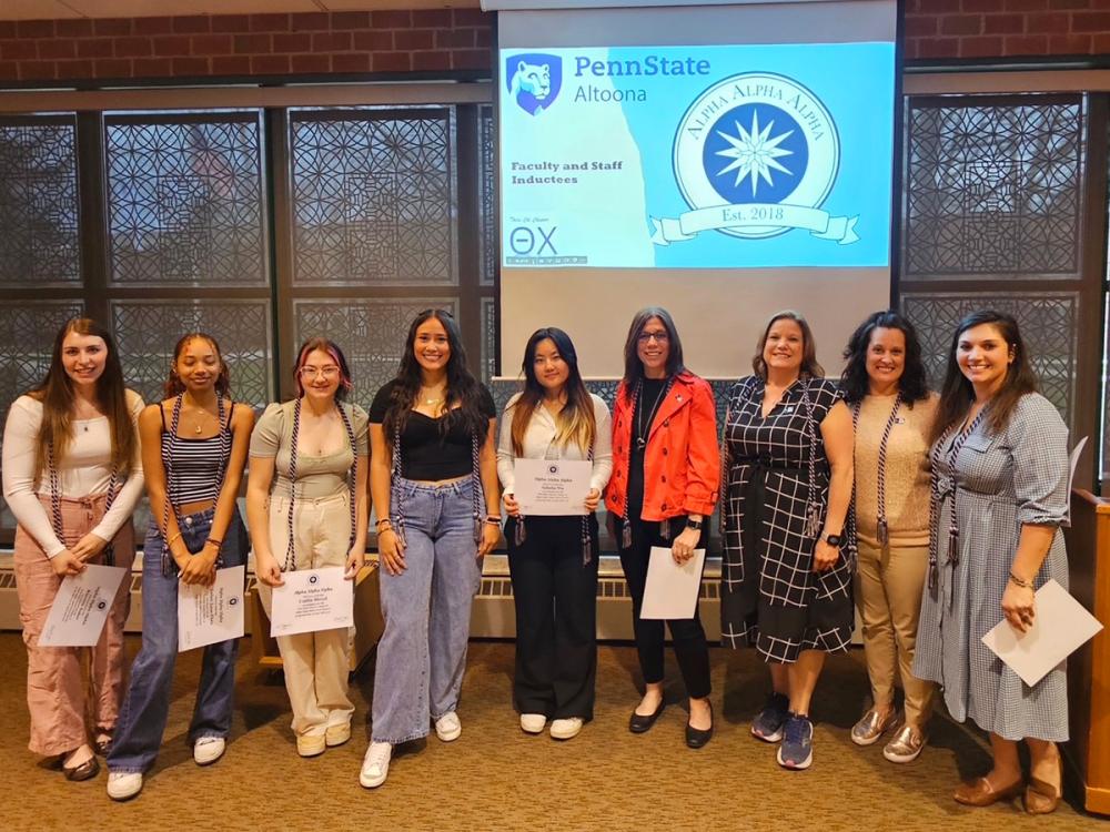 Ten students, faculty, and staff pose for a photo after being inducted into Tri-Alpha, an honor society for first-generation college students.
