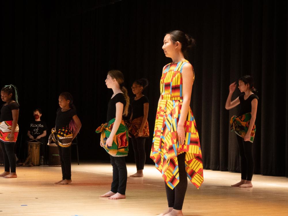 Dance instructor and children dancing on a stage at festival