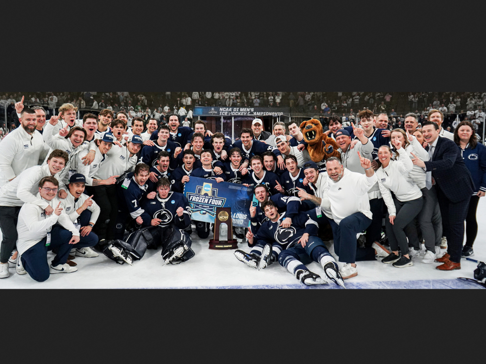 The members of the men's hockey team pose for a triumphant photo on the ice after a game